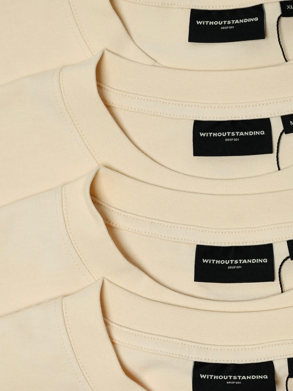 Stacked collars of seedpearl DROP 001 tees showing WITHOUTSTANDING labels