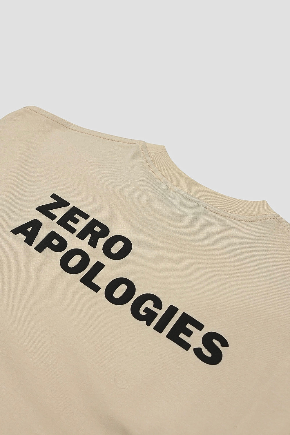 Angled close-up of the raised ZERO APOLOGIES puff print