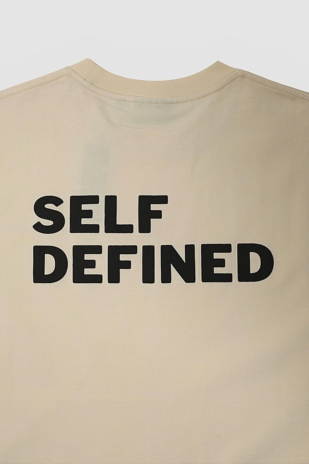 Upper back of the seedpearl DROP 001 tee with the SELF DEFINED raised print