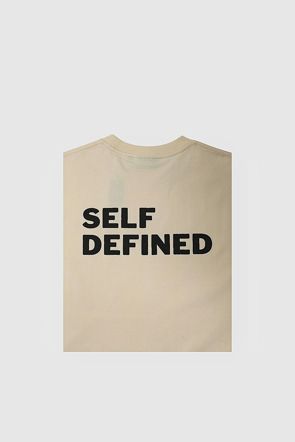 Folded seedpearl DROP 001 tee with the SELF DEFINED print visible