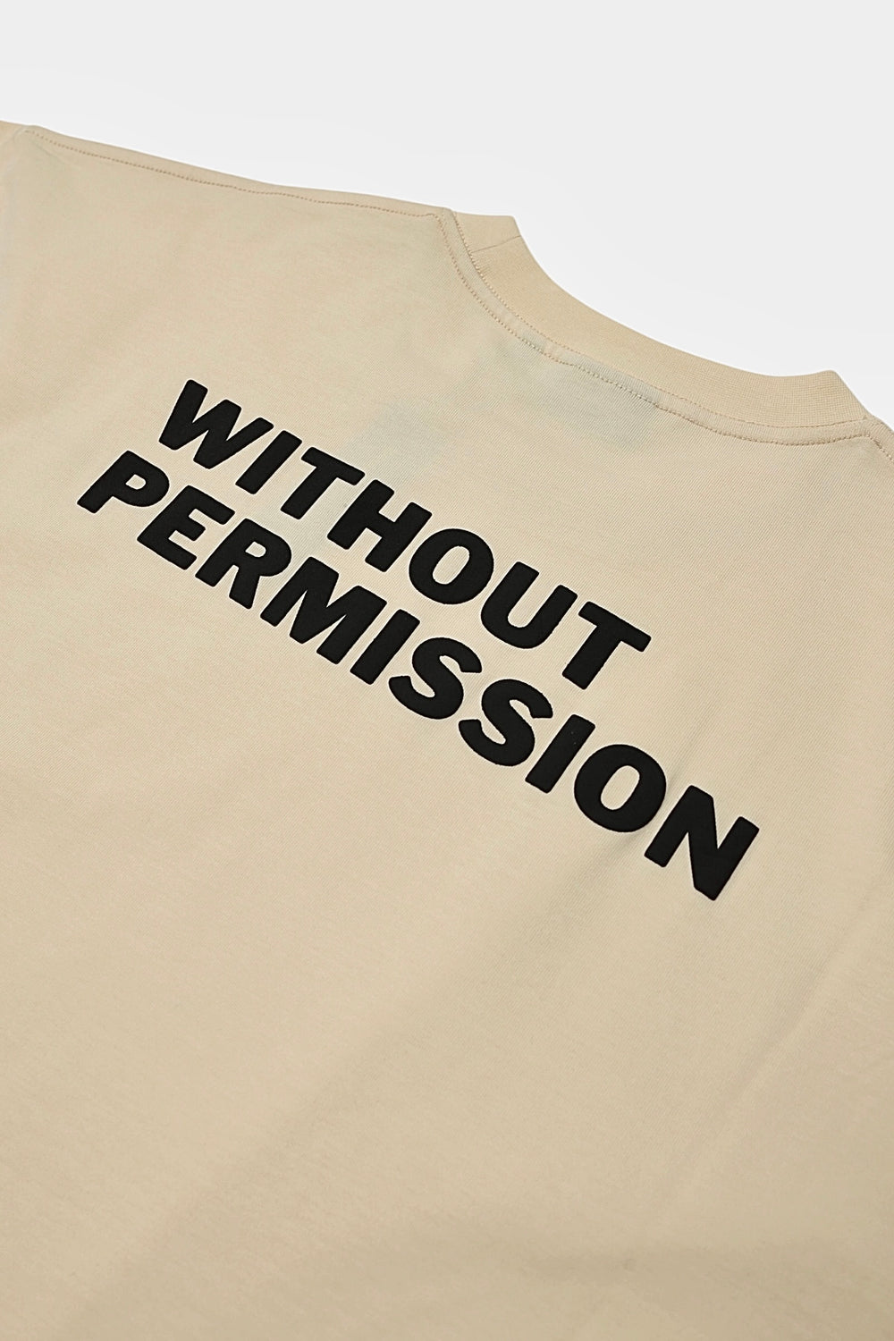 Angled close-up of the raised WITHOUT PERMISSION puff print