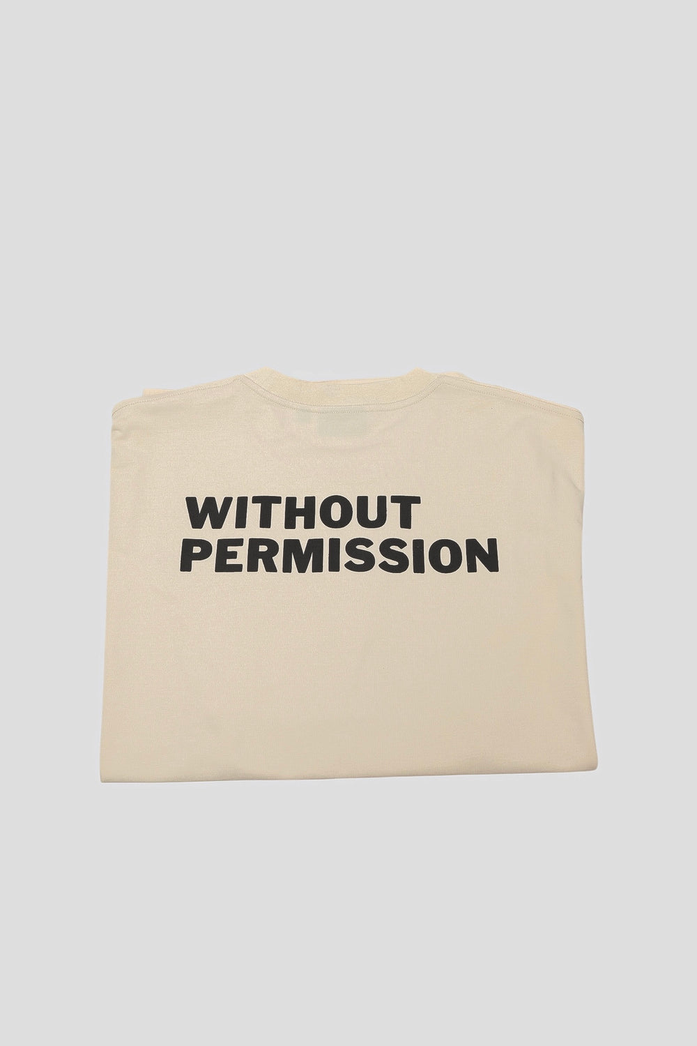 Folded seedpearl DROP 001 tee with the WITHOUT PERMISSION print visible